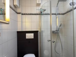 a bathroom with a shower and a toilet in it at Bungalow, Dornumersiel in Dornumersiel