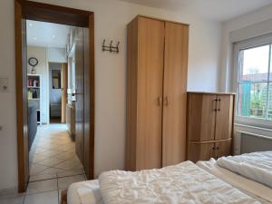 a bedroom with a bed and a wooden cabinet at Bungalow, Dornumersiel in Dornumersiel