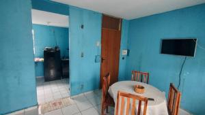 a blue room with a table and a television at Conforto in Maricota