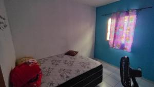 a bedroom with a bed and a blue wall at Conforto in Maricota