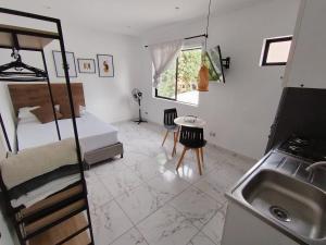 a bedroom with a bed and a sink and a kitchen at Casa Palma Poblado in Medellín