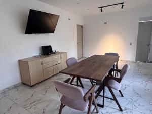 a dining room with a wooden table and chairs at Casa Palma Poblado in Medellín