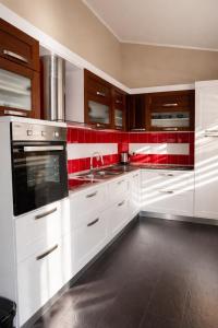 a kitchen with white cabinets and red tiles at Owen Rooftop in Shëngjin