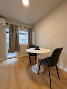 a living room with a table and two chairs at Apartman Amaya in Sarajevo +28 photos