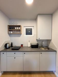 a kitchen with white cabinets and a sink at Apartman Amaya in Sarajevo