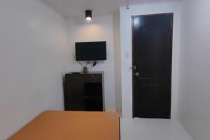 a bedroom with a black door and a television at Liane's Place Puerto Princesa in Puerto Princesa City +45 photos