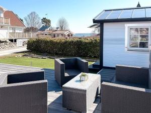 a patio with chairs and a table and a building at 4 star holiday home in SÖLVESBORG in Sölvesborg