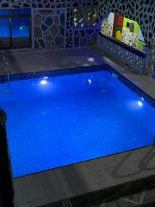 a large blue swimming pool with lights on it at Akomapa Village in Elmina