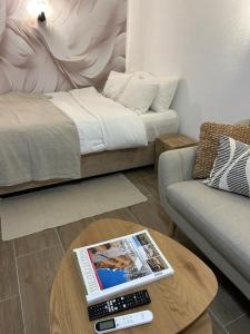 a living room with a bed and a table with a magazine at Studio BIANCA in Kotor
