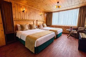 a hotel room with two beds and a couch at Denizci Hotel in Sinop