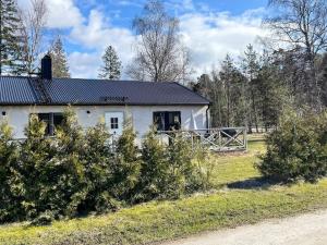 a white house with bushes in front of it at 4 person holiday home in KLINTEHAMN-By Traum in Klintehamn