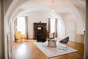 a living room with chairs and a table at KOKORO am Kirchplatz in Sankt Veit am Vogau