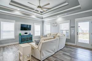 a living room with a white couch and a ceiling fan at Hannah Cabana home in Crystal Beach