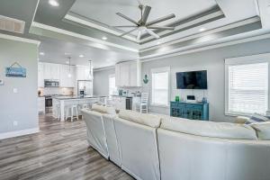 a living room with white furniture and a kitchen at Hannah Cabana home in Crystal Beach