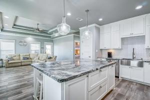 a kitchen with white cabinets and a large counter top at Hannah Cabana home in Crystal Beach