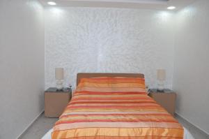 a bedroom with a bed with two night stands at Residence 33 orange in Guelmim