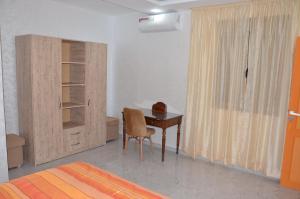 a bedroom with a desk and a cabinet and a bed at Residence 33 orange in Guelmim