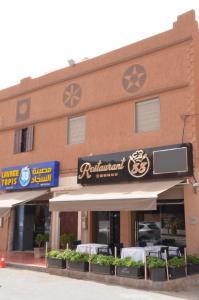 a restaurant with a sign on the side of a building at Residence 33 orange in Guelmim