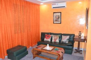 a living room with a green couch and a table at Residence 33 orange in Guelmim