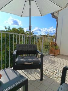 a black chair under an umbrella on a patio at casa del corso 27 in Sirolo