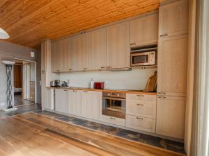 a kitchen with white cabinets and a wooden ceiling at Eistvere Puhkemaja in Eistvere