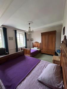 a large bedroom with two beds and a chandelier at Charmante maison en pleine campagne in Rollancourt
