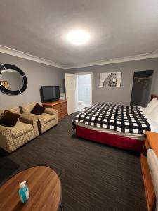 a large bedroom with a bed and a couch at Tulip Motel in Woodstock