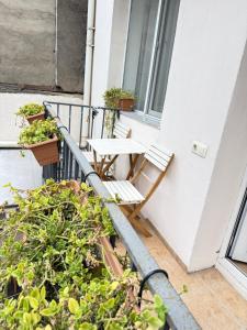 a table and chair on a balcony with plants at Downtown Hotel in Tbilisi City
