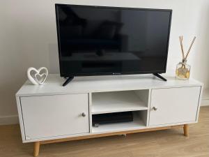 a white entertainment center with a flat screen tv on it at Appartement cosy proche Paris CDG RER B Disneyland Paris Parc Astérix in Le Blanc-Mesnil
