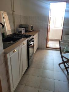 a small kitchen with a stove and a window at La Mare Apartments - 25 in Constanţa +6 photos