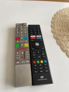 two remote controls sitting next to each other on a table at Appartement cosy proche Paris CDG RER B Disneyland Paris Parc Astérix in Le Blanc-Mesnil +40 photos