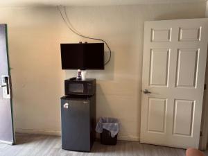 a room with a television and a refrigerator with a microwave at Border Motel in Calexico +18 photos