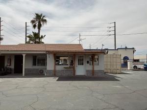 an old building with a palm tree in front of it at Border Motel in Calexico