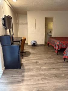 a room with a bedroom with a bed and a tv at Border Motel in Calexico