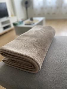a pile of towels sitting on top of a couch at Appartement cosy proche Paris CDG RER B Disneyland Paris Parc Astérix in Le Blanc-Mesnil