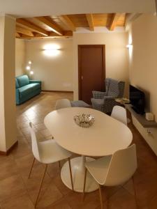 a dining room with a white table and chairs at Casa Vacanze al Lago P1 in Monasterolo del Castello