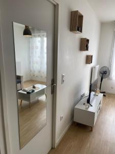 a mirror on a wall in a room with a table at Appartement cosy proche Paris CDG RER B Disneyland Paris Parc Astérix in Le Blanc-Mesnil