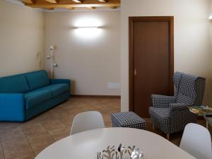 a living room with a couch and a table and chairs at Casa Vacanze al Lago P1 in Monasterolo del Castello