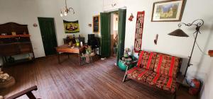 a living room with a table and a chair and a desk at Gran Casa Hostel&Camping in Tilcara +53 photos