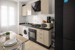 a kitchen with a stove top oven next to a table at résidence avec piscine wifi et parking gratuit in Bouskoura