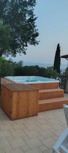 a hot tub with a wooden retaining wall and stairs at Viole Country Hotel in Assisi