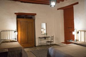 a bedroom with two beds and a table with a chair at La Casita de la Basílica in Pátzcuaro