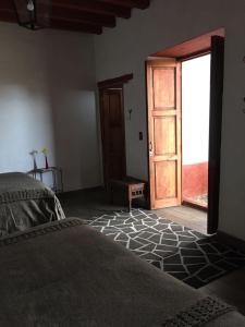 a bedroom with a bed and a door to a room at La Casita de la Basílica in Pátzcuaro