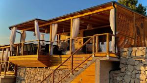 a house with a large deck with a stone wall at Sunset Coast - Paradise Cottage in Drage