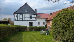 a black and white house with a table and chairs at Lohbachhof in Wolfhagen