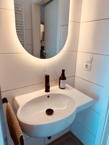 a bathroom with a sink and a mirror at Glacis Apartments I - Sonnenterasse & kostenlose Parkplätze in Minden +14 photos