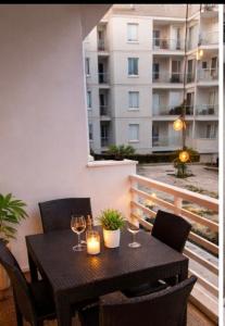 a table with wine glasses and candles on a balcony at résidence avec piscine wifi et parking gratuit in Bouskoura