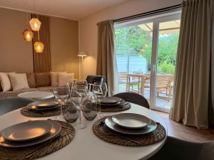 a dining table with plates and wine glasses on it at Glacis Apartments I - Sonnenterasse & kostenlose Parkplätze in Minden