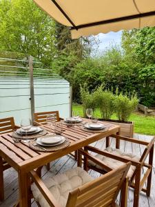 a wooden table and chairs on a deck with an umbrella at Glacis Apartments I - Sonnenterasse & kostenlose Parkplätze in Minden