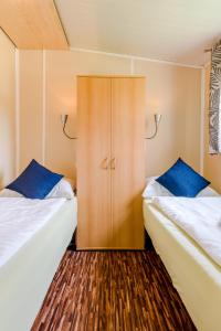 a bedroom with two beds and a cupboard at Relax Camping Seewirt in Feldkirchen in Kärnten